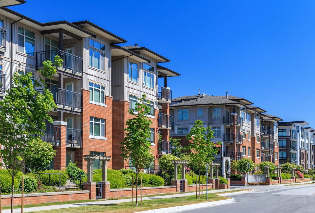 Modern brick apartment complex with balconies and landscaped grounds